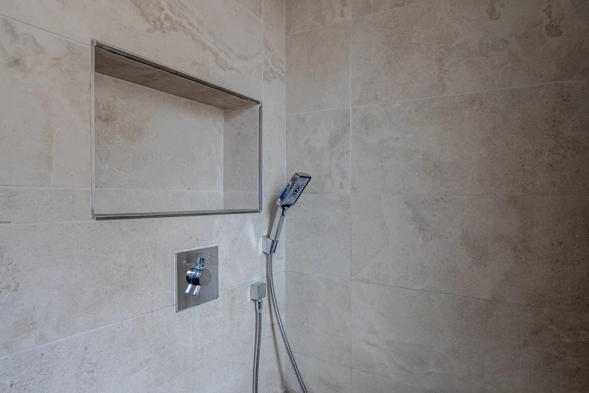 Détail d'une douche à l'italienne, niche et robinetterie encastrée, photographié par Julian Espin